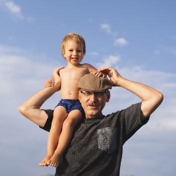 Grandpa holding grandson on shoulders Free Photo