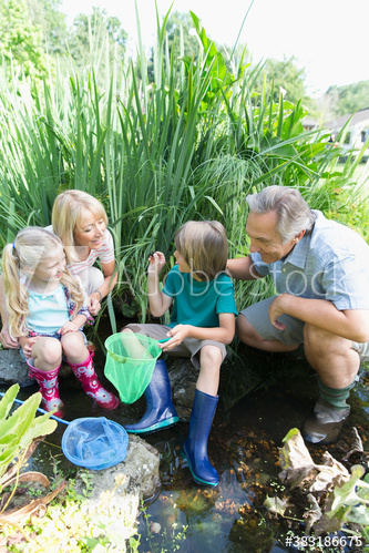 Grandparents and grandkids catching fish with nets
