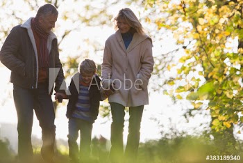 Grandparents and grandson walking in autumn park