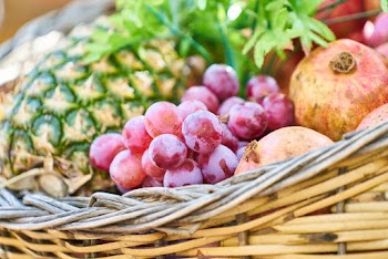 Grapes, Apple, and Pineapple on Brown Wicker Basket