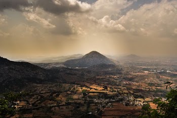 grass covered mountains near city during daytime
