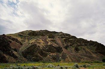 Grass`Field On The Foot Of A Mountain