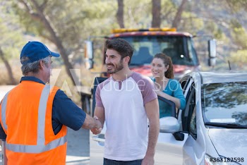 Grateful man shaking hands with roadside assistance mechanic
