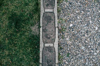Gravel and Grass Separated by Concrete Surface
