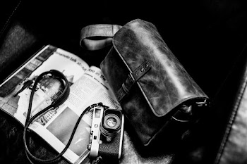 gray and black camera beside leather bag