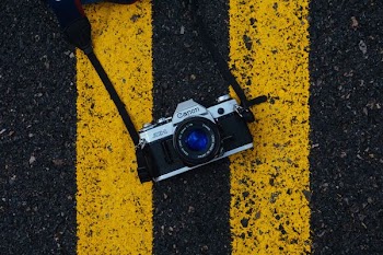 gray and black Canon SLR camera on road