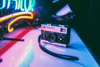 gray and black point-and-shoot camera on white surface in close-up photography