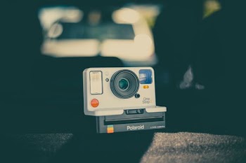 gray and black Polaroid camera on gray surface