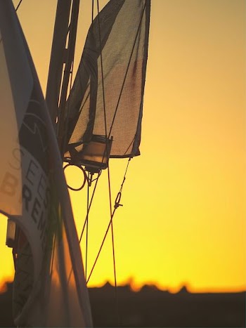 gray and black sailboat during sunset