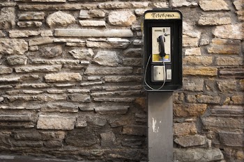 Gray and Black Telephone Booth Standing Near Gray Stone Wall at Daytime