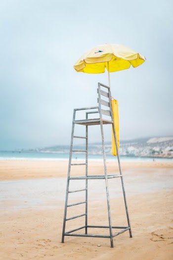 gray and brown lifeguard chair near body of water