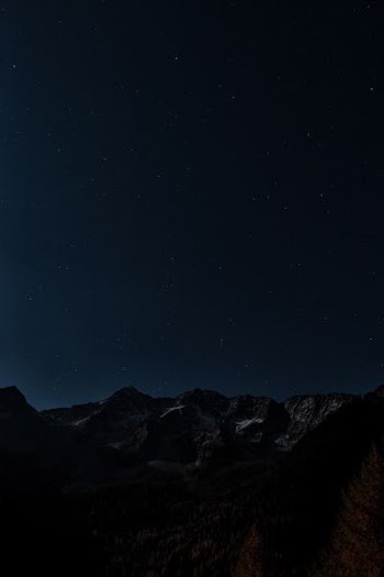 gray and brown mountains under starry night photo