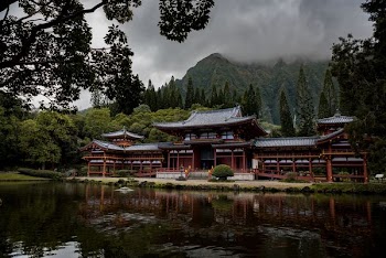 gray and brown pagoda temple beside calm body of water at daytime