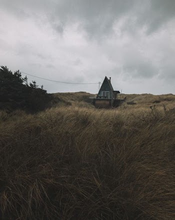 gray and brown wooden house under cloudy sky