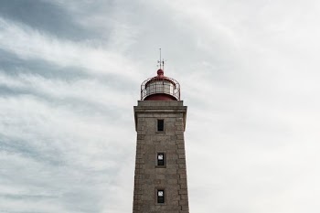 gray and red lighthouse low angle photo