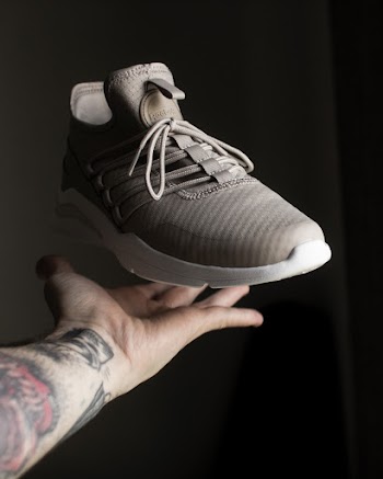 Gray and White Adidas Low-top Sneaker on Person's Fingers