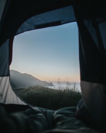 gray and white tent near body of water