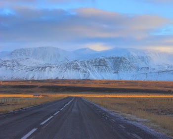 gray asphalt road in front of snow mountains