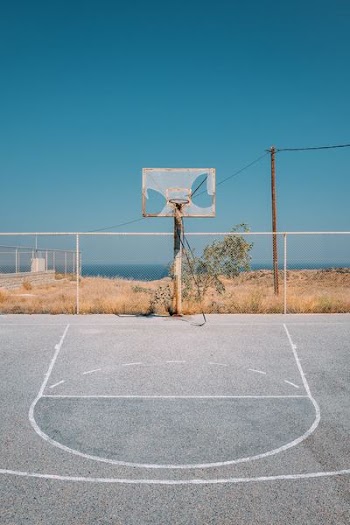 gray basketball field near body of water