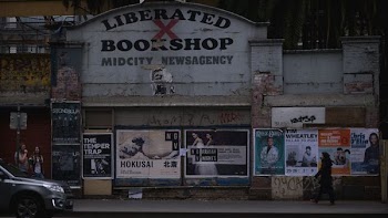 gray car in front of Liberated Bookshop sigange