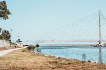 Gray Concrete Bridge Across the Body of Water Under Blue Sky