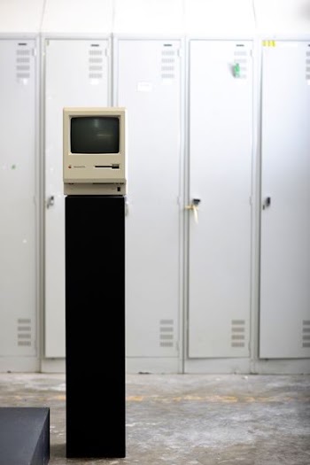 gray CRT monitor beside white locker
