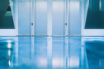 gray floor tiles and white wooden framed glass doors