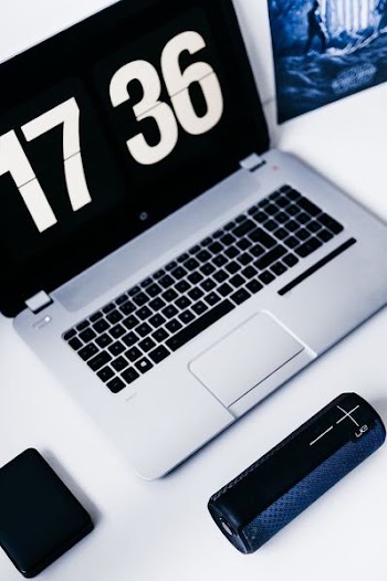 gray laptop computer near speaker