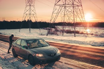 gray Mazda 3 on roadside during sunset