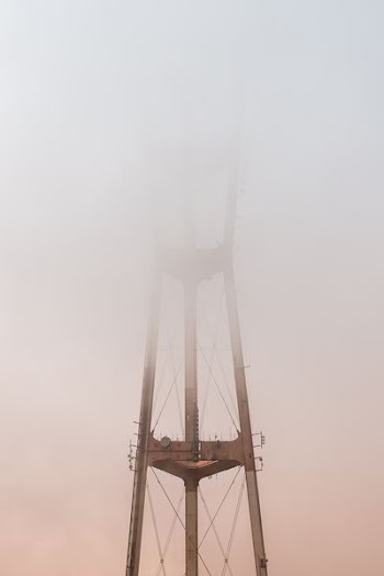 gray network tower covered by white clouds