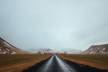 gray pave road near mountain during daytime