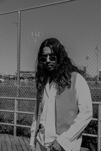 Gray scale Photo Man Standing Beside Chain Link Fence