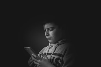 Gray-scale Photo of Boy Holding Smartphone