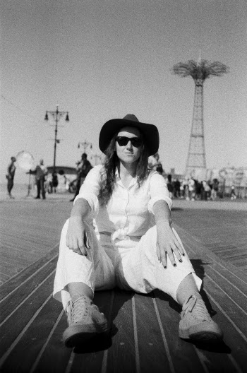 Gray scale Photo of Woman Wearing White Top and White Pants
