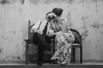 Gray scale photography of a couple kissing covering their faces with Bouquet of Flower