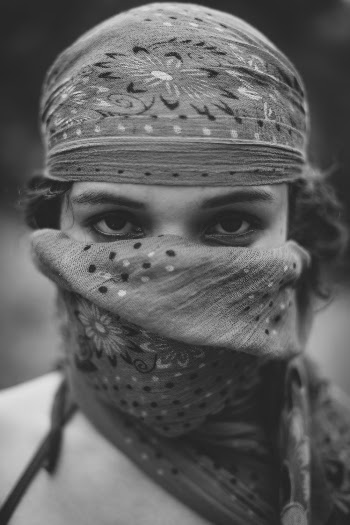Gray scale portrait photography of woman covering her face with kerchief
