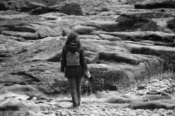 Gray Scale Woman in Black Hoodie Jacket on Concrete Rock