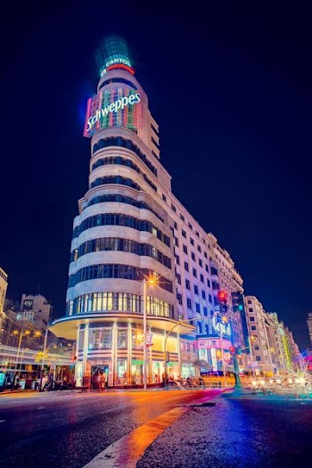 gray Schweppes building turn-on lights during night time