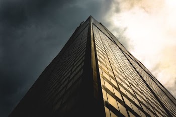 gray sky above black building low angle photography