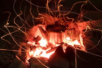 gray stainless steel kettle on fire pit