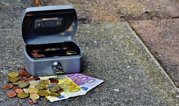 Gray Storage Box With Coins and Banknotes on Pavement