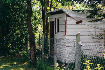 Gray Wooden House Beside Chain Link Fence
