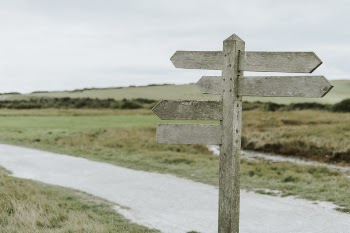 Gray Wooden Pedestal Signage Near Road
