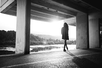 Graysale Photography of Walking Woman Near Body of Water