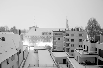 Grayscale of Houses Under Cloudy Sky