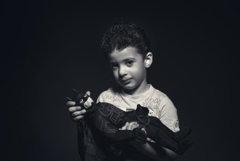 Grayscale Photo of a boy Holding Batman Plush Toy