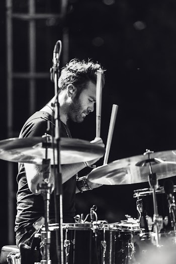 Grayscale Photo of a man playing drums