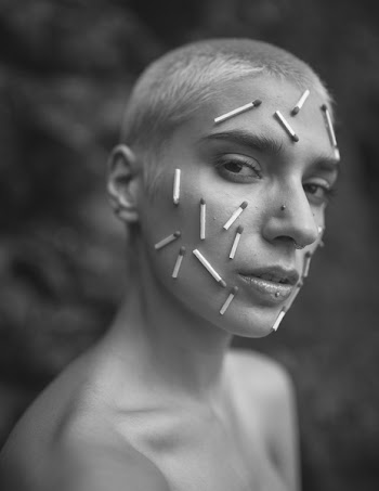 Grayscale Photo of a Person With Matchsticks on Face