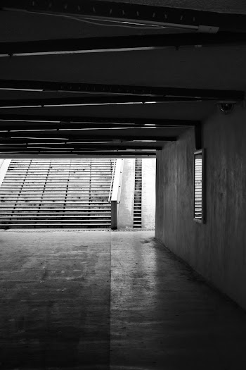 Grayscale Photo of a Tunnel and Stairs