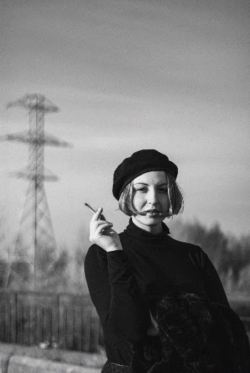 Grayscale Photo of a Woman Holding a Cigar 